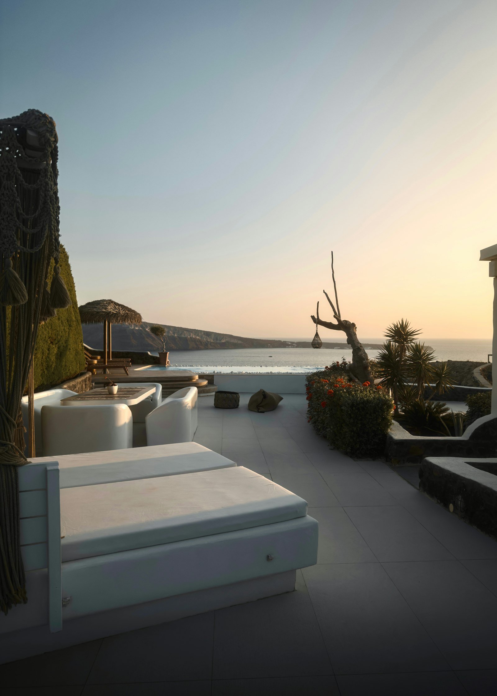 Luxury Santorini poolside lounge overlooking the sea at sunset